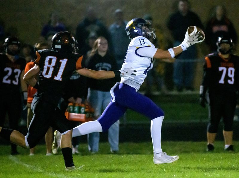 Farmington's Jack Gronewold (13) snags a reception past Elmwood/Brimfield's Tommy Burkitt in the first half of their Week 5 high school football game Friday, Sept. 27, 2024 in Elmwood. The Farmers defeated the Trojans 40-0.