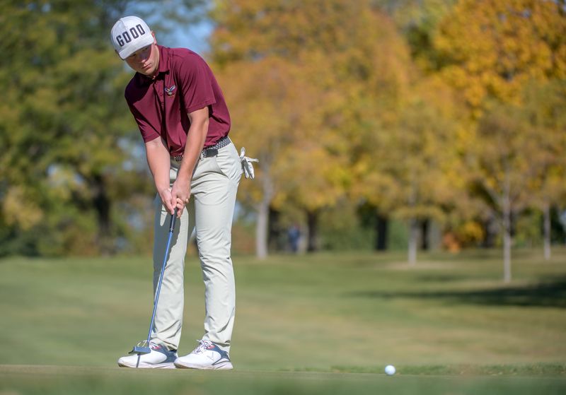 Dunlap's Nolan Eccles putts on No. 11 during the final round of the Class 2A Boys State Golf Championship on Saturday, Oct. 19, 2024 at Weibring Golf Club in Normal. Watching over him in the background is East Peoria boys golf head coach Matt Plummer.