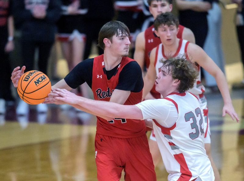 Morton’s Wes Gudeman (32) tries to poke the ball away from Metamora’s Jonah Funk in the second half of the Class 3A Dunlap Regional title game Friday, Feb. 28, 2025 at Dunlap High School. The Redbirds took the title 45-43.