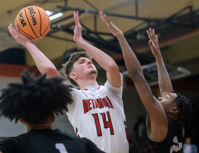 Metamora's Jonah Funk, left, shoots over Peoria High's LeShawn Stowers in the first half of the Class 3A Washington Sectional basketball title game Friday, March 7, 2025 at Washington Community High School. The Lions defeated the Redbirds 57-48.