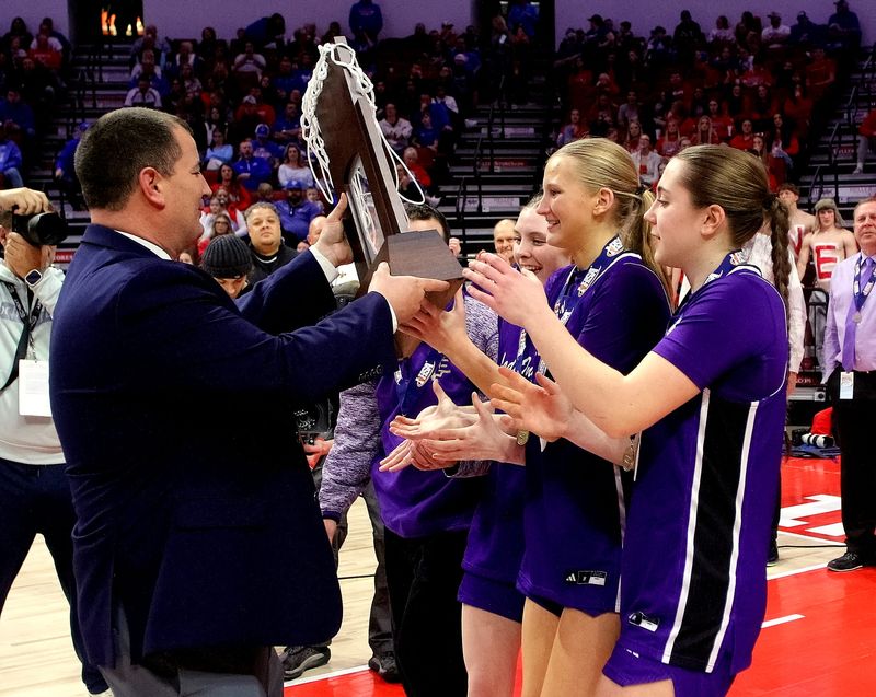 March 8, 2025 - Normal, Illinois - Pecatonica captains Kianna Degner, Payton Thomas and Elaina Rager accept the team's championship trophy during the Class 1A championship awards ceremony at the IHSA Girls Basketball State Finals on Saturday. The Indians won this year's state title 63-45 in their first appearance in school history in the state finals. (PhotoNews Media/Clark Brooks)