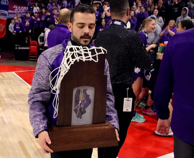 March 8, 2025 - Normal, Illinois - Pecatonica head coach Dan Rosenstiel carries the team's first state championship trophy after the awards ceremony for the Class 1A championship at the IHSA Girls Basketball State Finals on Saturday. The Indians won this year's state title 63-45 in their first appearance in school history in the state finals. (PhotoNews Media/Clark Brooks)