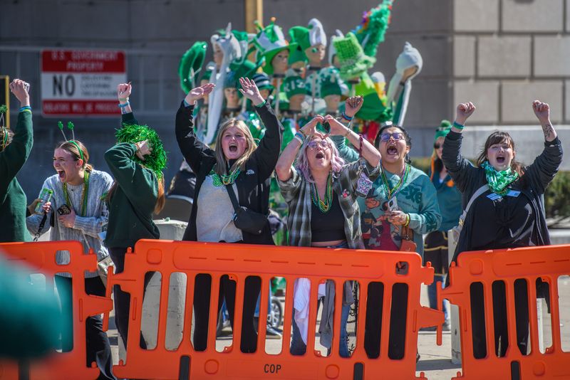 A group of enthusiastic parade-goers cheer for a float during the annual St. Patrick’s Day Parade on Monday, March 17, 2025 through downtown Peoria.