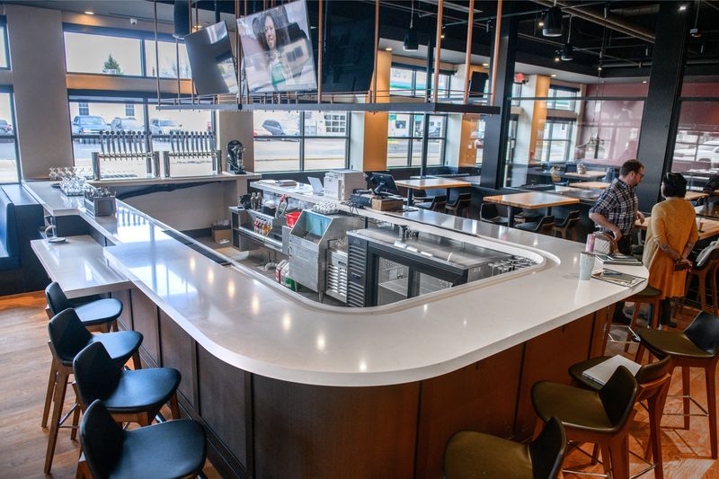 A horseshoe-shaped bar stands as the centerpiece of the new Tangled Roots Craft Beer & Kitchen on the square in Washington. The tavern opened for business April 9, 2025.
