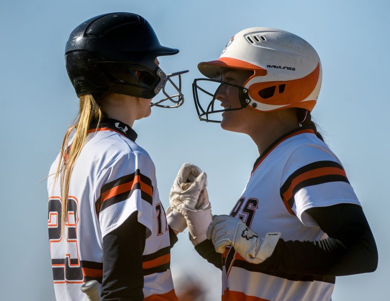 Illini Bluffs’ Lexi Brinkman, right, confers with teammate Emerson Eeten before an at-bat against Brimfield during their high school softball game Tuesday, April 8, 2025 in Washington. The Tigers defeated the Indians 1-0.