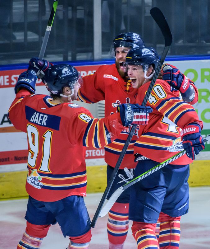 Peoria's Alec Baer (91) and JM Piotrowski (40) celebrate with teammate Jordan Ernst after Ernst's game-winning goal against Quad City in sudden-death overtime in Game 1 of the first round of the SPHL hockey playoffs Thursday, April 10, 2025 at Carver Arena. The Rivermen defeated the Storm 5-4.