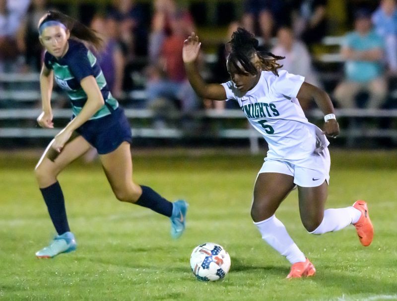 Richwoods’ Acosia Morris (5) moves the ball against Peoria Notre Dame’s Emy Wardle in the second half of their girls high school soccer match Wednesday, April 23, 2025 at PND High School. The match ended in a scoreless tie.