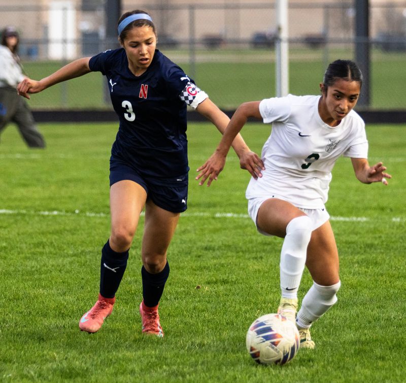 Boylan’s Delilah Hawley (9) runs with the ball while being tailed by Belvidere North’s Haylee Gallas (3) during a game on Thursday, April 24, 2025, at Belvidere North High School.
