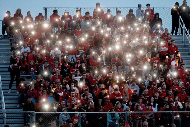 Some of those attending the candlelight vigil at the Glenwood High School stadium hold up light during the ceremony Monday, April 30, 2025 to remember the victims of Monday's crash in Chatham.