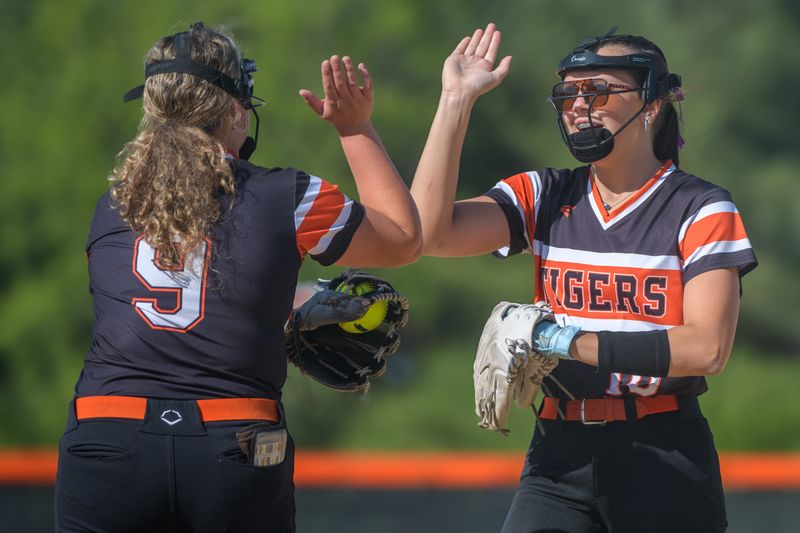 Illini Bluffs first baseman Anabelle Reimer, right, high-fives pitcher Cora Ellison after an out against Delavan in the Class 1A Glasford Regional softball title game Friday, May 23, 2025.