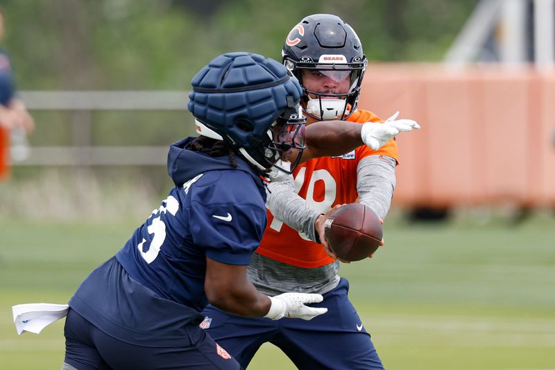 Jun 3, 2025; Lake Forest, IL, USA; Chicago Bears quarterback Caleb Williams (18) passes the ball to running back Kyle Monangai (25) during minicamp at Halas Hall. Mandatory Credit: Kamil Krzaczynski-Imagn Images