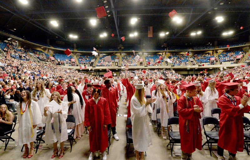Glenwood High School graduates throw their caps into the air at the conclusion of the commencement ceremony at the Bank of Springfield Center on June 7, 2025.