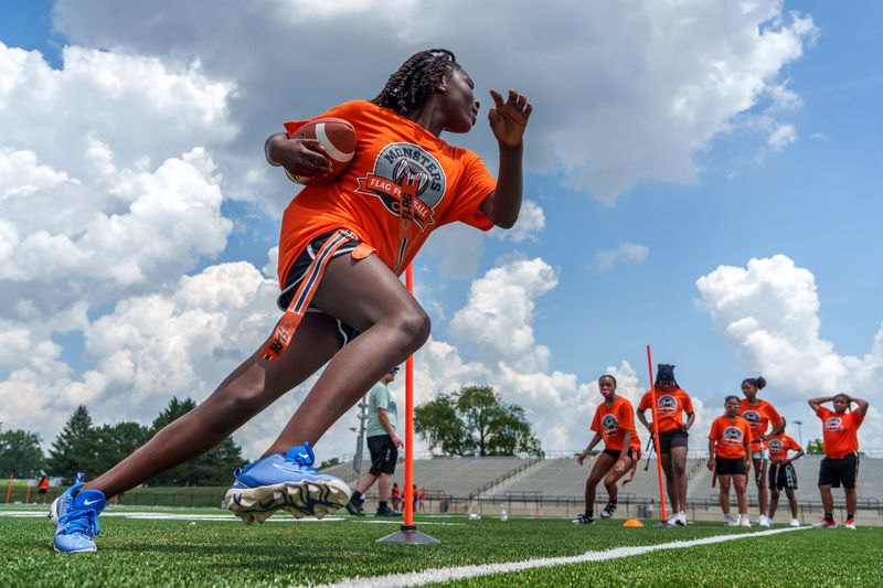 A flag football player keeps an eye out for her opponent during a drill at the Monsters Flag Football Clinic on Wednesday, June 25, 2025 at Peoria Stadium. The Chicago Bears created and sponsor the event which was hosted by Peoria Public Schools. Dozens of local girls of high school age and younger learned the basics and some new skills from local volunteer coaches.