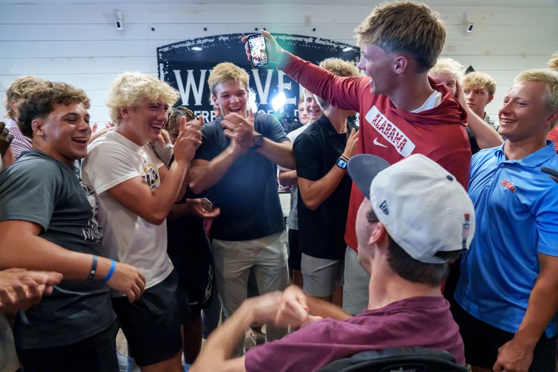 Dunlap senior Mack Sutter, at right in Alamaba shirt, celebrates with his friends and teammates after announcing his commitment to play football at the famous SEC school during a gathering Thursday, June 26, 2025 at Weaver's Fresh Food & Drink in Peoria.