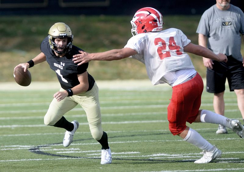 Sacred Heart-Griffin's Cam Brinkman scrambles with the ball to avoid a sack during the scrimmage with Centralia Friday, August 22, 2025.