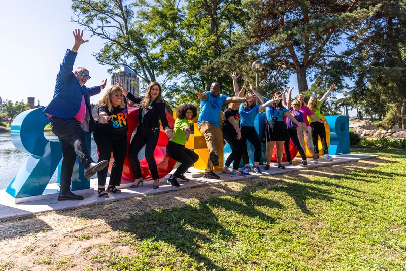 Members of the GoRockford team pose for a picture Aug. 27, 2025, in front of the Rockford letters in downtown Rockford.