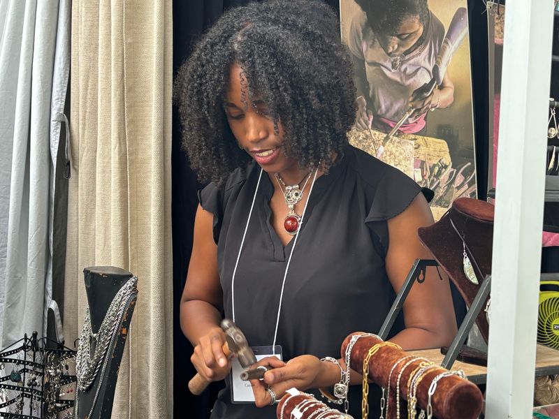 Bianca Gedeon of Crestview, Fla., sizes a ring for Jennifer Rockwell of Springfield, Ill., at the Edwards Place Fine Art Fair on Sept. 21, 2024.