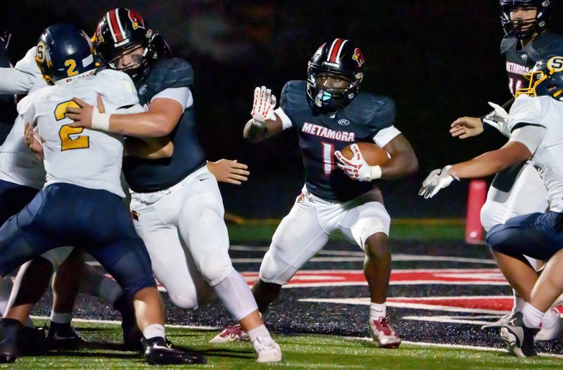 Metamora’s Jaiduan Cranford runs the ball against Sterling in the second half of their high school football opener Friday, Aug. 29, 2025 at Metamora Township High School. The Redbirds routed the Golden Warriors 43-14.