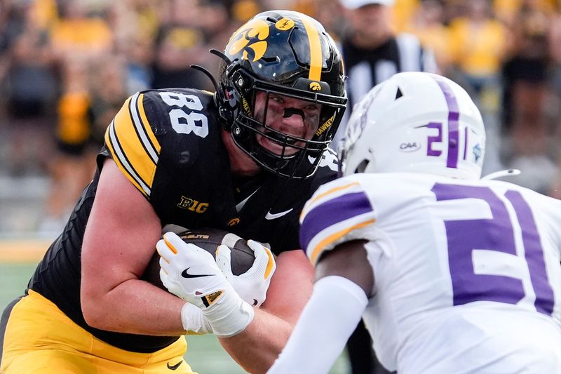 Iowa Hawkeyes tight end Hayden Large (88) carries the ball toward Albany Great Danes defensive back Erv Wiggins Jr. (21) Aug. 30, 2025 at Kinnick Stadium in Iowa City, Iowa.
