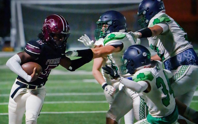 Peoria High quarterback Breon Greene tries to avoid the Peoria Notre Dame defense in the second half of their Week 2 high school football game Friday, Sept. 5, 2025 at Peoria Stadium. The Lions defeated the Irish 58-31.
