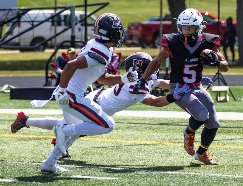 Auburn’s Gavin Sanders (5) attempts to elude two Harlem defenders during a game on Sept. 6, 2025, at Auburn High School.