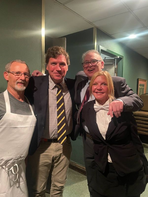 Tucker Carlson stands for a photo with staff members at Jim's Steak House on Sept. 5. He visited the restaurant during a wedding rehearsal dinner.