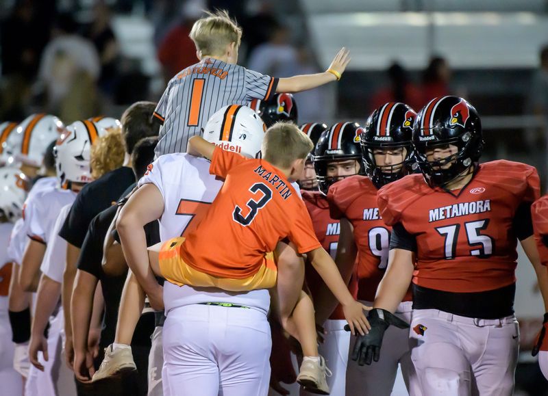 A pair of Washington ball boys join in the line at the end of the Panthers’ 24-0 win over Metamora on Friday, Sept. 12, 2025 in Metamora.