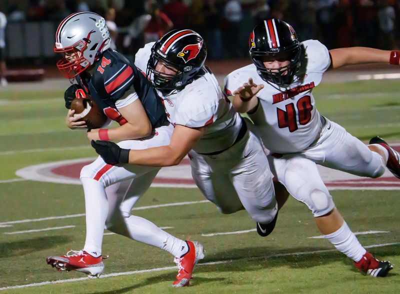 Metamora’s A.J. Ioerger, middle, and Remington Lemkemann chase down Morton quarterback Brody Fritz in the second half of their Week 4 high school football game Friday, Sept. 19, 2025 in Morton. The Redbirds defeated the Potters 43-40.