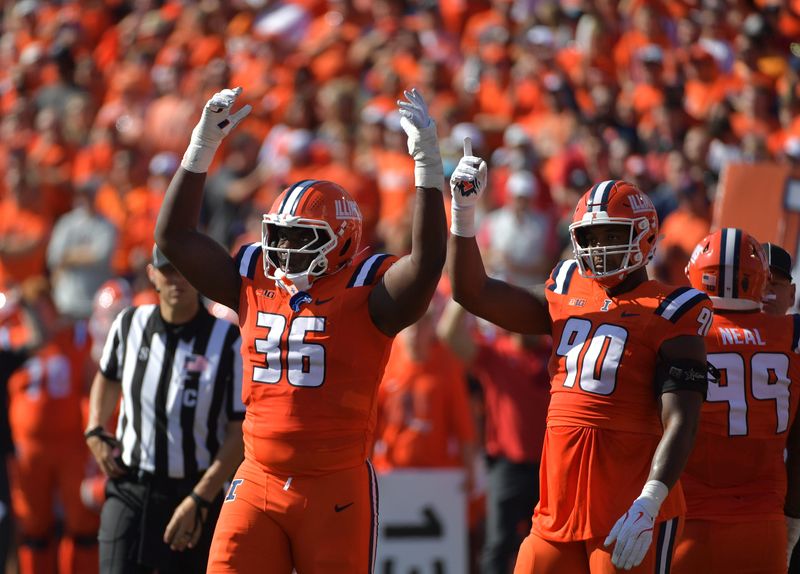 Oct 11, 2025; Champaign, Illinois, USA; Illinois Fighting Illini defensive lineman Tomiwa Durojaiye (36) and defensive lineman James Thompson Jr. (90) react during the first quarter against the Ohio State Buckeyes at Memorial Stadium. Mandatory Credit: Ron Johnson-Imagn Images