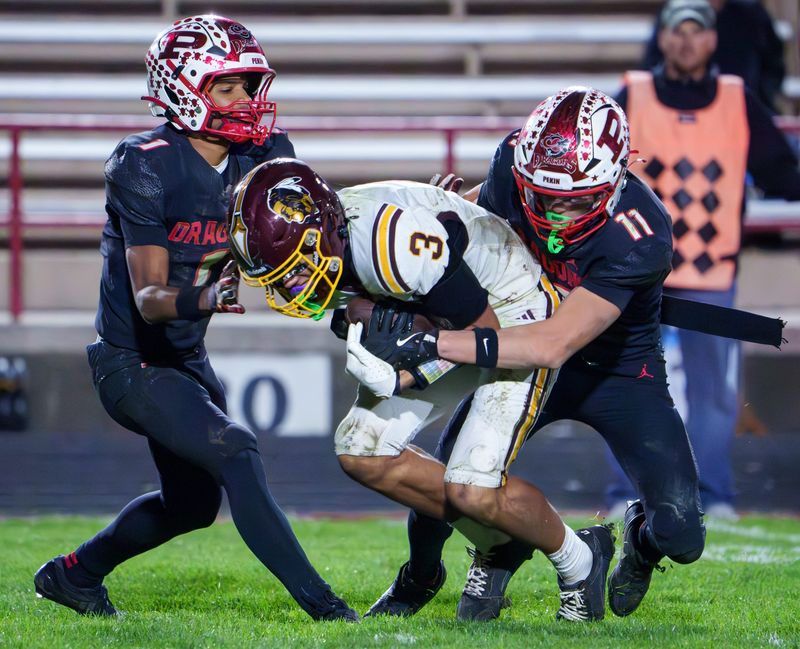 Pekin’s Teigan McCoy (11) and Bray Kormah (1) bring down East Peoria’s Keimon Lee in the second half of their Week 9 high school football game Friday, Oct. 24, 2025 in Pekin. The Dragons defeated the Raiders 35-14.
