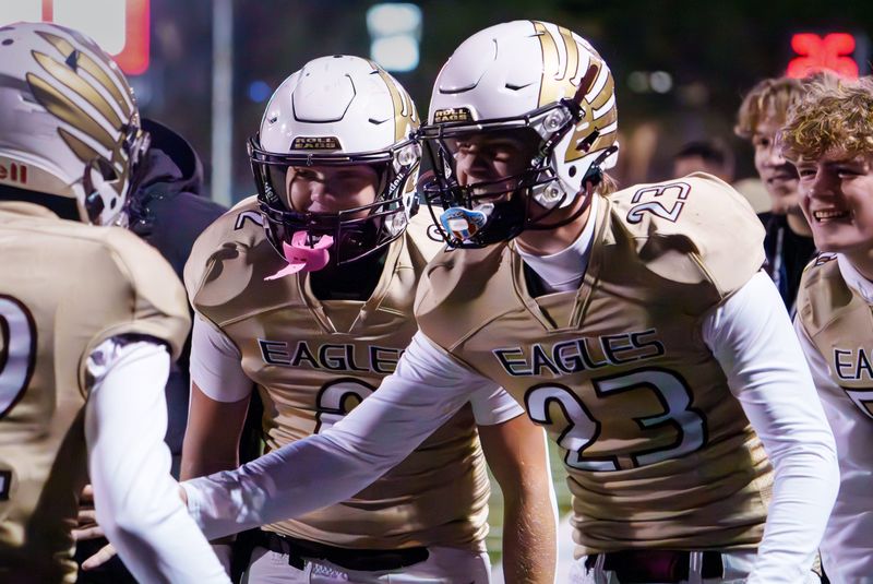 Dunlap's Holden Lee (23) and Samuel Hjort (2) congratulate Jacob Gleason on his first-half touchdown against Pekin in the first round of the Class 6A high school football playoffs Friday, Oct. 31, 2025 in Dunlap. The Eagles advanced to the second round with a 42-21 victory.