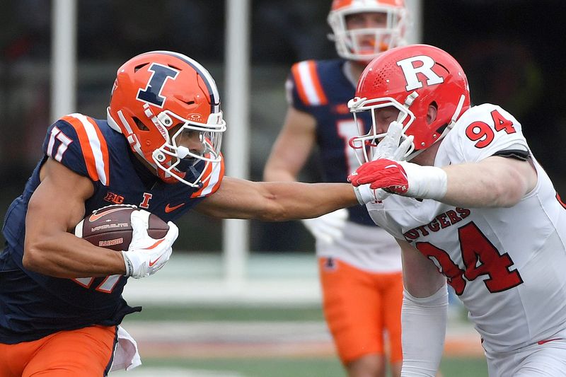 Nov 1, 2025; Champaign, Illinois, USA; Illinois Fighting Illini wide receiver Collin Dixon (17) stiff arms Rutgers Scarlet Knights defensive lineman Bradley Weaver (94) during the first half at Memorial Stadium. Mandatory Credit: Ron Johnson-Imagn Images