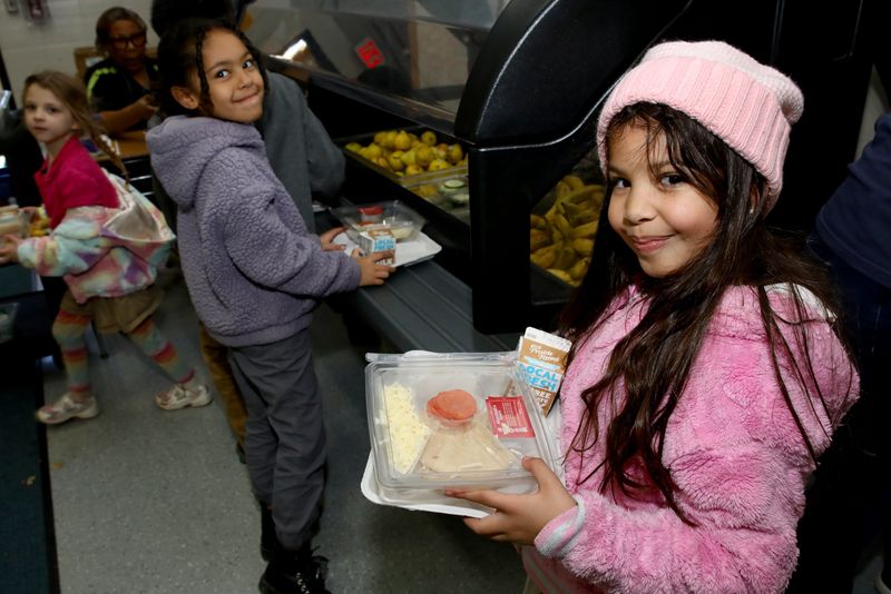Emma Ramirez Plaza, right, a first grader at Rockford's STEAM Academy at Haskell, carries her lunch in line on Nov. 3, 2025, at the school.