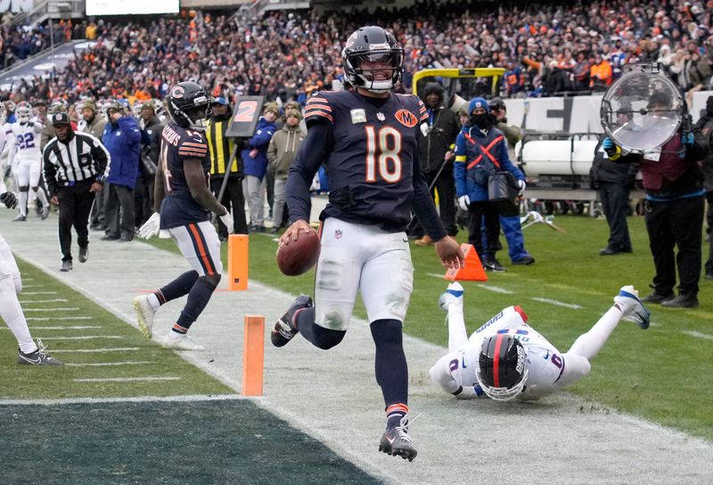 Nov 9, 2025; Chicago, Illinois, USA; Chicago Bears quarterback Caleb Williams (18) scores the game-winning touchdown against New York Giants linebacker Brian Burns (0) during the fourth quarter at Soldier Field. Mandatory Credit: David Banks-Imagn Images