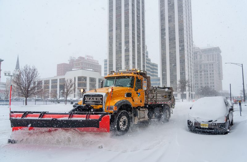A plow clears snow on SW Jefferson Avenue as a steady snowfall covers the area Saturday, Dec. 13, 2025 in Peoria.