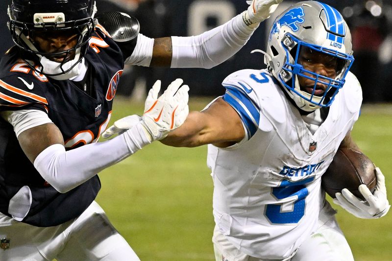 Jan 4, 2026; Chicago, Illinois, USA; Detroit Lions running back David Montgomery (5) runs with the ball against Chicago Bears cornerback Nahshon Wright (26) during the second half at Soldier Field. Mandatory Credit: Matt Marton-Imagn Images