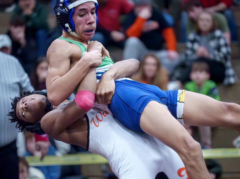 Washington’s Micah Jackson throws Peoria Notre Dame’s Jesus DeLa Cruz in the 113-pound championship match during the Class 2A wrestling regionals Saturday, Jan. 31, 2026 at Metamora Township High School. Jackson won in a 6-5 decision.
