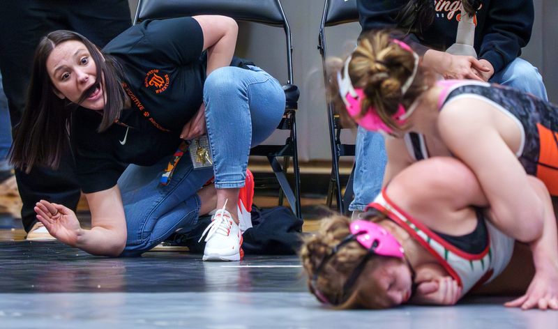 Washington girls wrestling coach Summer Smith gives some instructions to Paytyn Dykes, top, as she battles LaSalle-Peru's Audi Plut in the 145-pound championship match of the girls regionals Saturday, Feb. 7, 2026 at Normal West High School. Dykes took the title with a 4-0 decision.