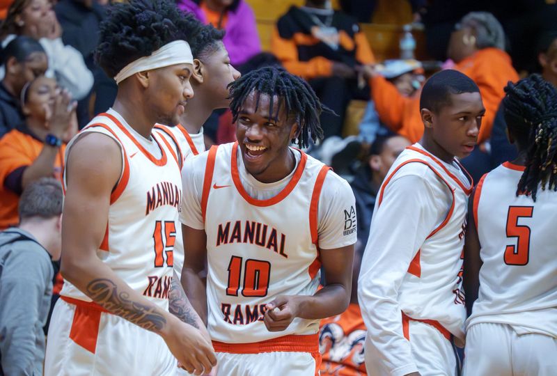Manual's Jaquan Brown (10) laughs with teammate Rico Booker late in the fourth quarter of their Class 2A boys high school basketball sectional semifinal Tuesday, March 3, 2026 at IVC High School in Chillicothe. The Rams advanced to the sectional title game with a 66-42 win over the Riverdale Rams.