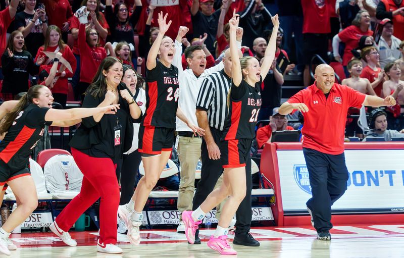 Dee-Mack players and staff run onto the court after the Chiefs defeated Mt. Pulaski 49-34 for the IHSA Class 1A girls high school basketball state title game Saturday, March 7, 2026 at CEFCU Arena in Normal.