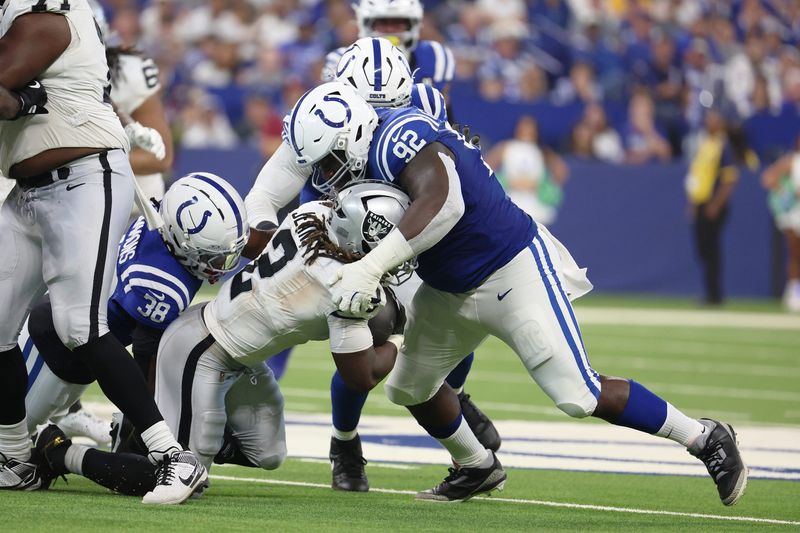 Oct 5, 2025; Indianapolis, Indiana, USA; Indianapolis Colts defensive tackle Neville Gallimore (92) tackles Las Vegas Raiders running back Ashton Jeanty (2) during the second quarter at Lucas Oil Stadium. Mandatory Credit: Trevor Ruszkowski-Imagn Images
