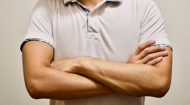 Crossed arms close up of man.