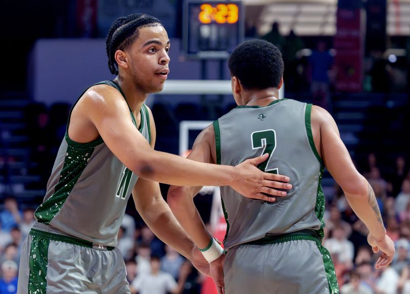 Richwoods’ Anfernee Moore, left, pats teammate Amarion Smith-Holley on the back after a score against Chicago Marist in the second half of the Class 4A supersectional Monday, March 9, 2026 at CEFCU Arena in Normal. The Knights fell to the RedHawks 56-53.