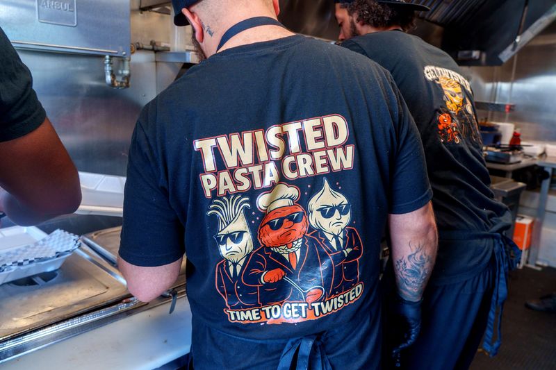 The Twisted Pasta Crew sports some custom workwear as they fill food truck orders during a recent stop in Bartonville.