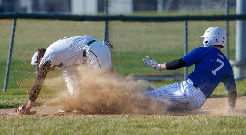 Limestone’s Joe Shields (7) kicks up some dirt sliding into third base as Richwoods third baseman Ethan Reynolds tries to field an errant throw from home on a steal attempt during their high school baseball game Monday, March 23, 2026 at Richwoods High School. The Rockets prevailed 4-3.