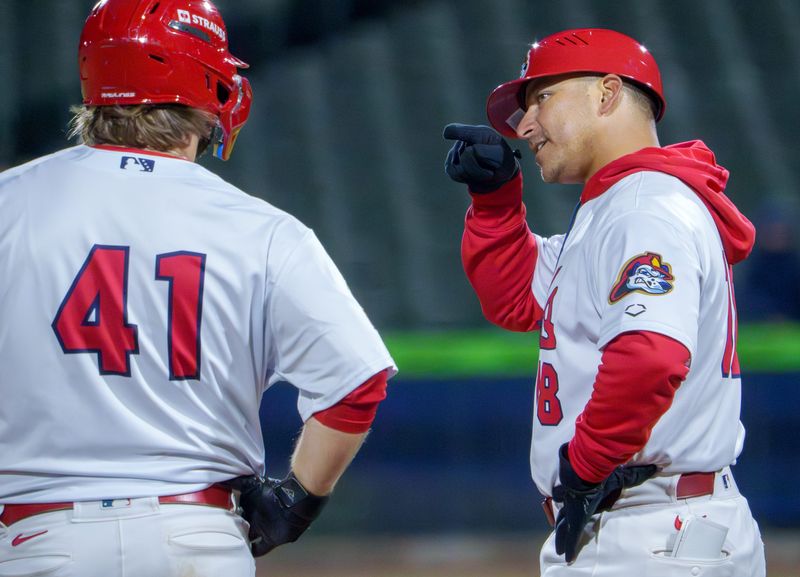 Peoria Chiefs manager Roberto Espinoza, right, talks with baserunner Josh Kross during a break in the action against South Bend in the Chiefs' home opener Tuesday, April 7, 2026 at Dozer Park. The Chiefs routed the Cubs 10-1.