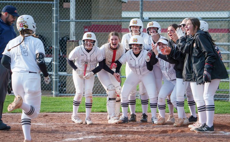 The Metamora Redbirds greet teammate Addyson Wooden (12) at the plate after he game-tying home run against Washington during their high school softball game Tuesday, April 7, 2026 in Metamora. The Panthers defeated the Redbirds 11-9.