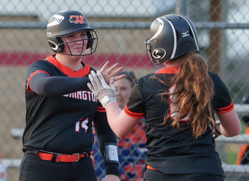 Washington’s Addy MacGregor, left, high-fives teammate Sophie Walker after her score against Metamora during their high school softball game Tuesday, April 7, 2026 in Metamora. The Panthers defeated the Redbirds 11-9.