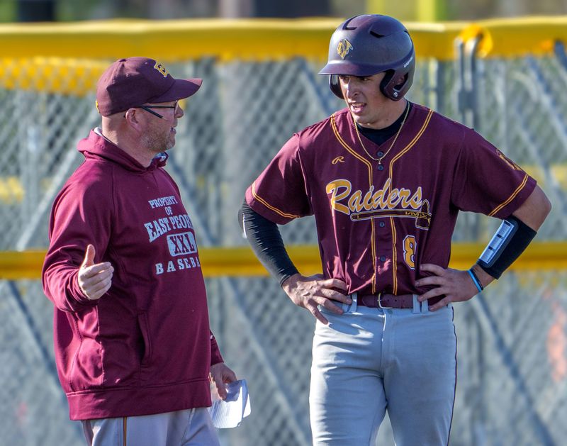 East Peoria head coach Matt Plummer talks with R.J. Duncheon as the Raiders battle Limestone during their high school baseball game Wednesday, April 8, 2026 at EastSide Centre in East Peoria. The Raiders routed the Rockets 12-2 in six innings.
