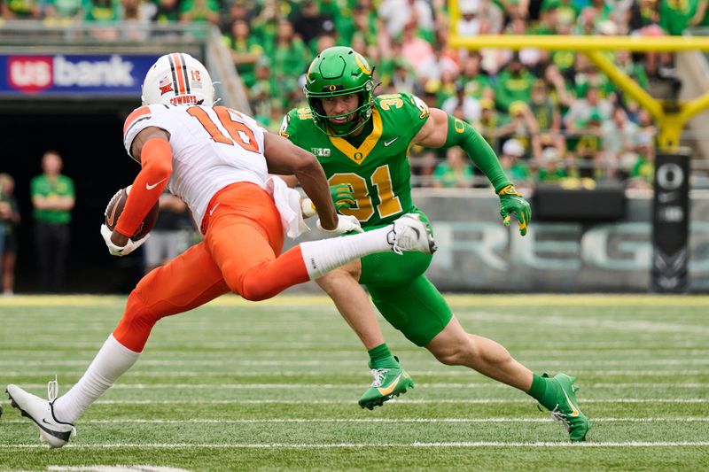 Sep 6, 2025; Eugene, Oregon, USA; Oregon Ducks defensive back Dillon Thieneman (31) runs after Oklahoma State Cowboys wide receiver Christian Fitzpatrick (16) during the first half at Autzen Stadium. Mandatory Credit: Troy Wayrynen-Imagn Images